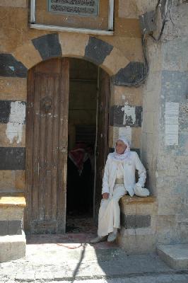 Assis devant sa mosquée, il attend les copains